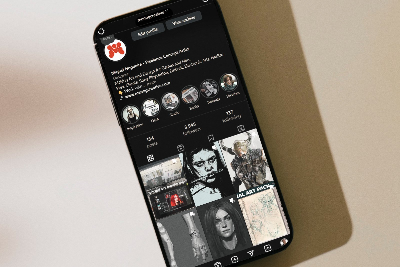 Smartphone displaying an Instagram profile of Miguel Nogueira, a freelance concept artist, showing profile picture, bio, highlights, and recent artwork posts.