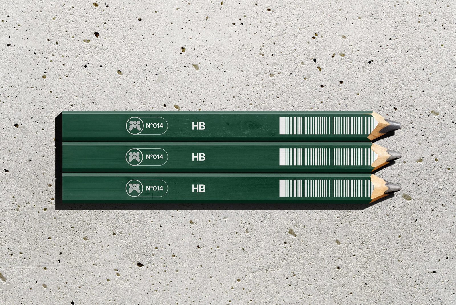 Three green pencils with barcodes and labels, arranged parallel on a textured surface.