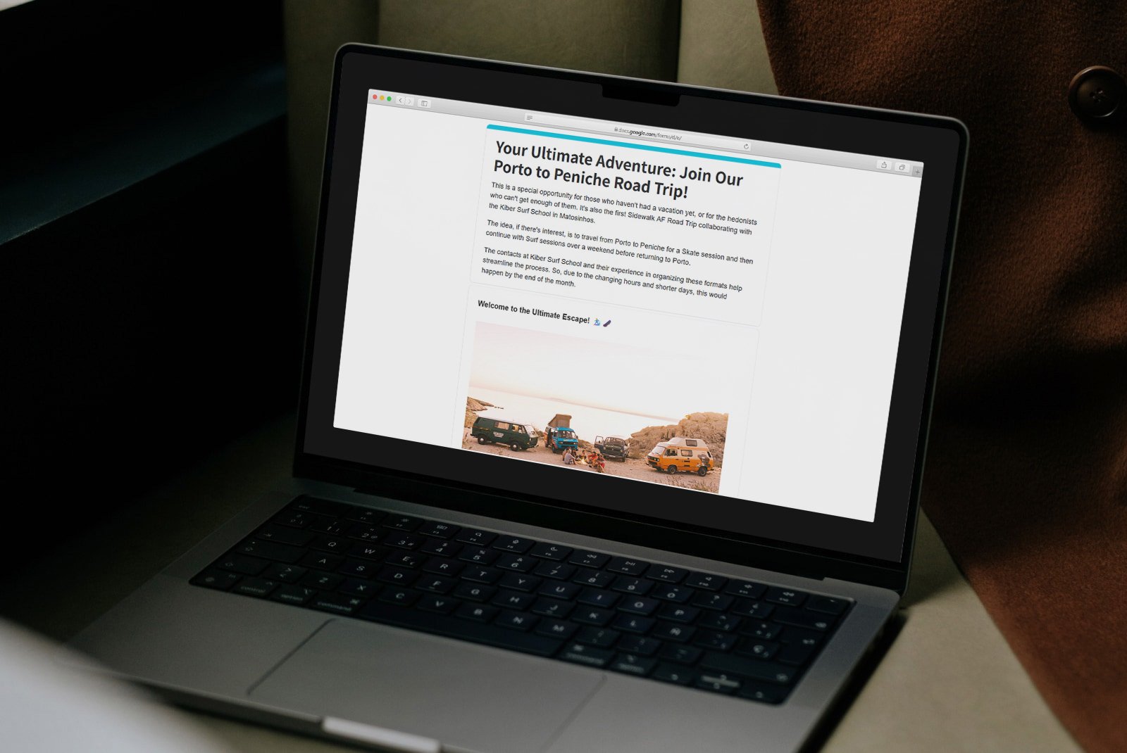 A laptop displaying a webpage about a road trip adventure to Peniche Porto with an image of vans parked on a beach.
