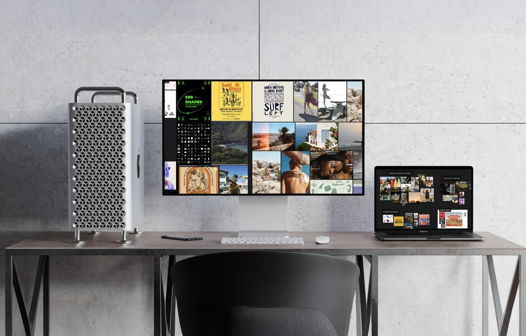 A workspace featuring a large desktop monitor, a laptop, a wireless keyboard, a mouse, and a silver computer tower against a concrete wall.